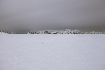 Snowy meadow with dolomitic mountain background, Col Visentin, Italy