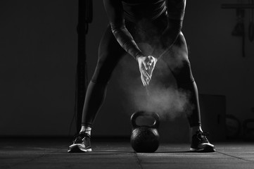 Close-up - Young muscular man working out in gym. Athletic male adult exercising with kettle bell. Fitness, sports concept. - obrazy, fototapety, plakaty