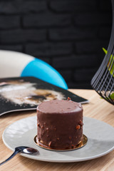 Mini mousse cake covered with chocolate glaze on gray plate