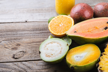 tropical exotic  fruits papaya,  guava, orange, passion on rustic wooden  background