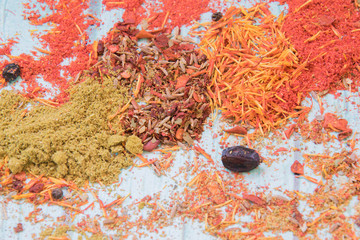 Yellow, orange, red and green spices on the blue wooden background