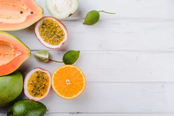 Poster tropical exotic  fruits papaya,  guava, orange, passion on white background, top view © sola_sola