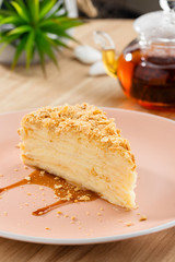 Slice of traditional napoleon cake on pink plate
