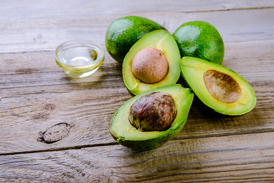 ripe avocado and avocado oil on  wooden background