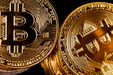 Macro view of shiny coins with Bitcoin symbol on dark background