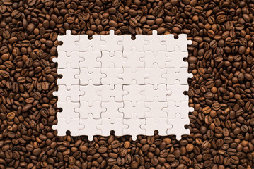 White jigsaw puzzle on coffee beans background. Copy Space