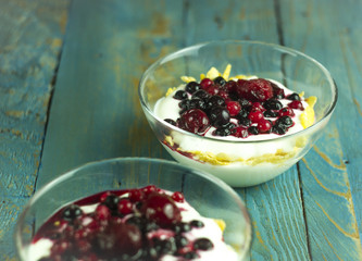Natural yogurt with berries on a wooden table for a sweet snack