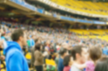 Fototapeta premium Blurred standed up crowd of spectators in stadium at a sporting event