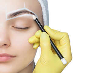 Permanent make-up for eyebrows of beautiful woman with thick brows in beauty salon. Closeup...