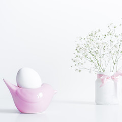 White Egg in Pink Bird Shape Stand.Easter Composition
