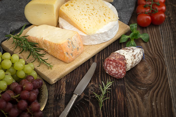 Cheeses with basil, rosemary, tomatoes, grapes and salame.