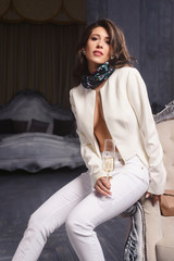 Fashion portrait of attractive young festive brunette business woman holding a glass of champagne