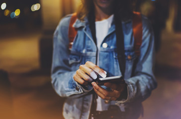 Woman pointing finger on blank screen smartphone on background bokeh light in night atmospheric city, blogger hipster using in hands gadget mobile phone closeup street, online wifi internet concept