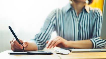 graphic designer working at office with digital stylus on background monitor computer, hipster manager using device pen, hands close up graw on portable tablet, work process concept in workplace