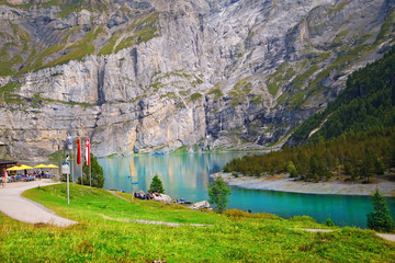 beautiful blue natural lake oeschinensee, in Switzerland, a fantastic mountain landscape overlooking the water and forest