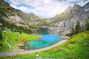 Plakat beautiful blue natural lake oeschinensee, in Switzerland, a fantastic mountain landscape overlooking the water and forest