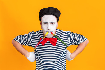 Portrait of stupid mime man play in birthday pipe