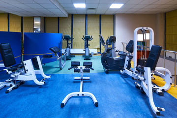 Fototapeta premium Interior of a fitness hall gym. Equipment and Machines at the Empty Modern Gym Room. Fitness Center.