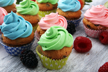Tasty cupcakes on wooden background. Birthday cupcake in rainbow colors