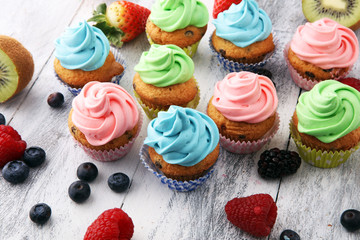 Tasty cupcakes on wooden background. Birthday cupcake in rainbow colors