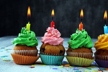 Tasty cupcakes on wooden background. Birthday cupcake in rainbow colors