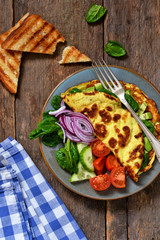 Omelette with avocado, spinach and vegetables with crispy toast from bread. Morning breakfast.