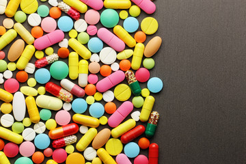 Fototapeta na wymiar Colorful pills on grey background