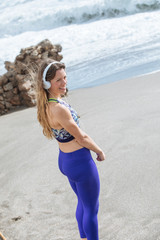 happy young woman listening music with her headphones on the beach
