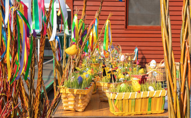 Traditional souvenirs displayed on the table during Easter market. Baskets with easter eggs,...