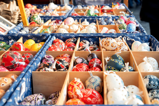 Wide selection of easter eggs, traditional souvenirs in the kiosk of street market during celebration of Easter in Central  Europe. Compartments full of colourfull eggs. Focus in the center of image.