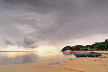 Sunset over balangay or bangka boats stranded on Punta Ballo beach-Sipalay-Philippines.0348