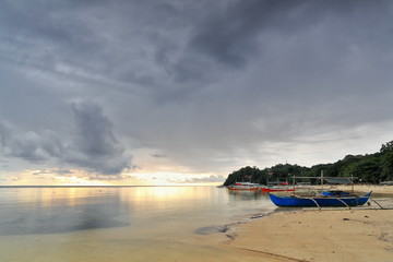 Fototapeta premium Sunset over stranded balangay or bangka boats. Punta Ballo beach-Sipalay-Philippines.0349
