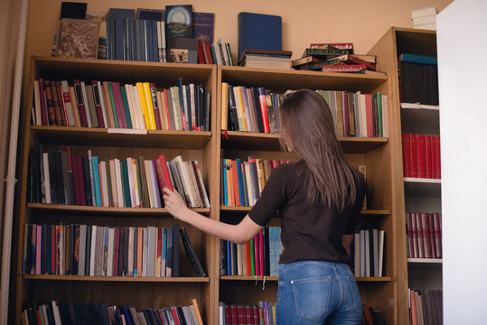 Woman selecting book from shelf