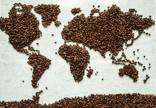 The world map from coffee beans on a light concrete background