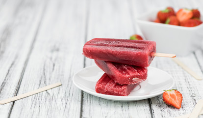 Old wooden table with homemade Strawberry Popsicles - obrazy, fototapety, plakaty