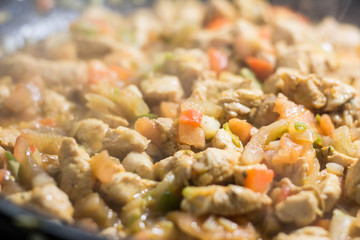 Cooking burrito in a pan with chicken, pepper, tomato for fajitas typical .Latin America food