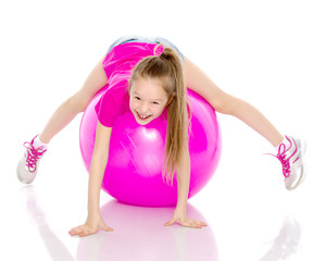 Obraz na płótnie Canvas little girl doing exercises on a big ball for fitness.