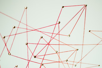 Background. Abstract concept (idea) of network, social media, internet, teamwork,  communication abstract. Thumbtacks linked together by red thread. Isolated. Entities connected.