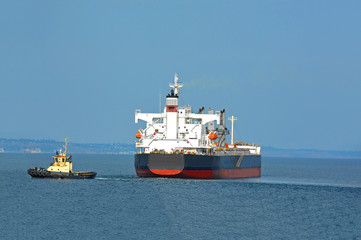 Tugboat assisting bulk cargo ship