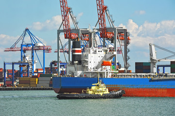 Fototapeta premium Tugboat assisting bulk cargo ship