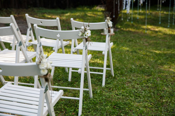 Chairs with wedding decor for guests at wedding ceremony