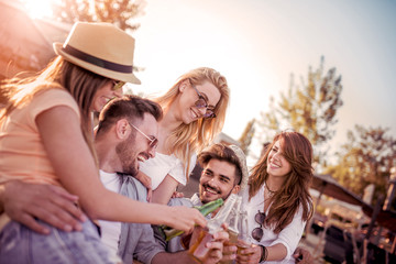 Group of happy people sitting together on the beach