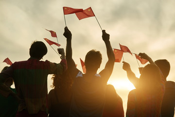 Group of people waving chineese flags. People raising chineese flags up to the sky.