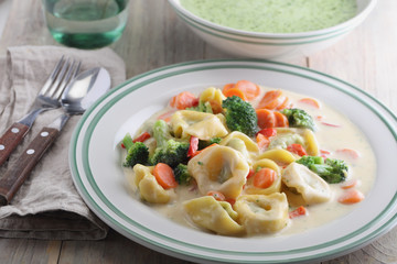Tortellini with vegetables under cream sauce