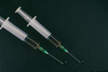 The concept of drug addiction. Background from blurry in dark colors, multi-exposure images of a syringe with a drug.