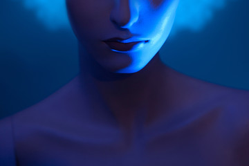 Lips of a woman. Mannequin on a blue background. Part of a woman's face.