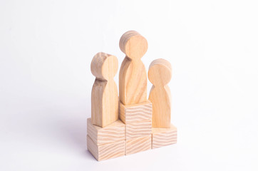 Three wooden figures of a man stand on the podium of the winners. The concept of victory, business competition and competition among employees. Olympiad and Paraolympic Games, Universiade.