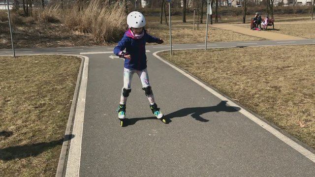 Little girl learn to ride on her roller skates.