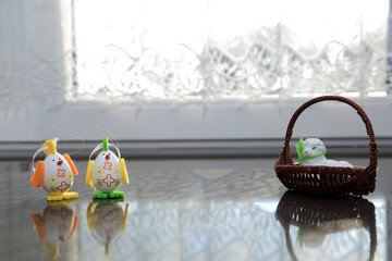 Jajka Wielkanocne w kształcie kurcząt i baranek w koszyczku na parapecie okna.