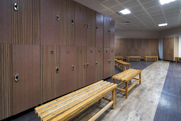 Interior of gym locker room. Luxury and clean dressing room with wooden benches